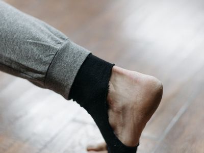 A person's feet on a wooden floor, suggesting grounding and stability.
